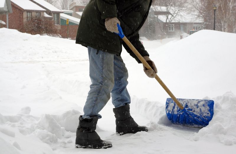 A young man shoveling deep snow