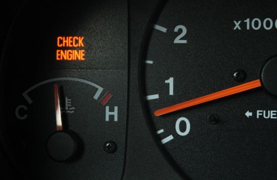 Close-up of "check engine" light on car dashboard.