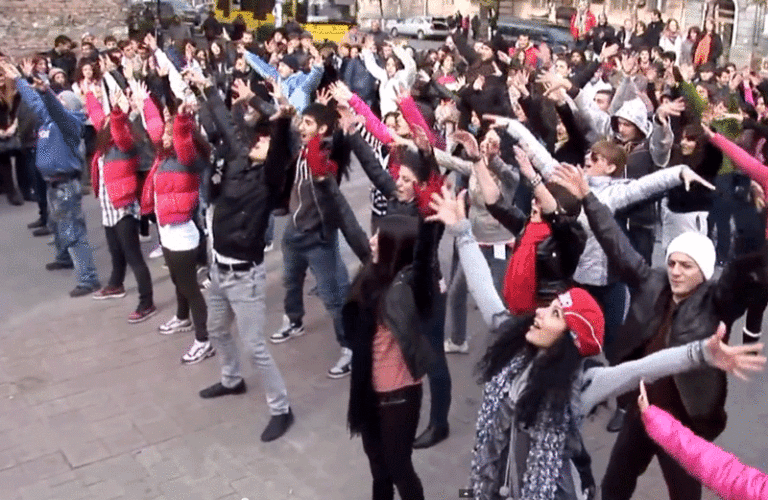 Group dances together in the middle of town's square