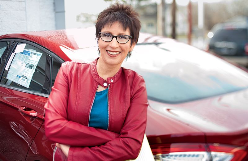 Susan Karas poses by the new car she purchased.