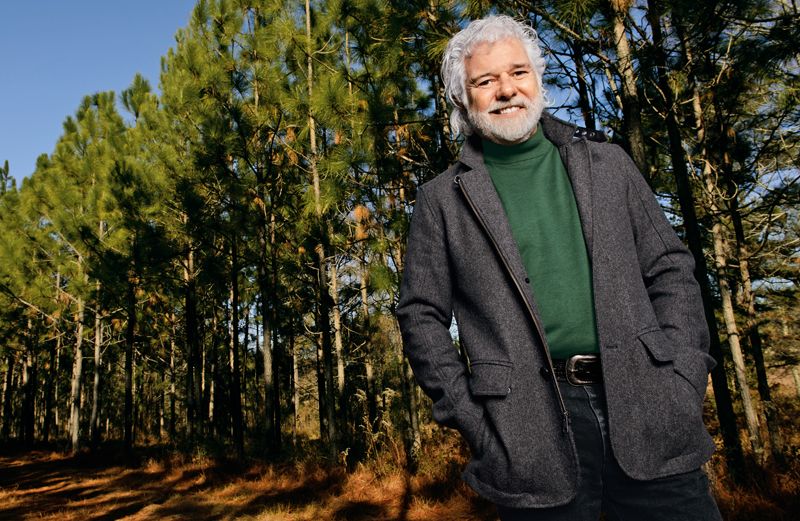 Chuck Leavell poses in front of a long row of his trees.