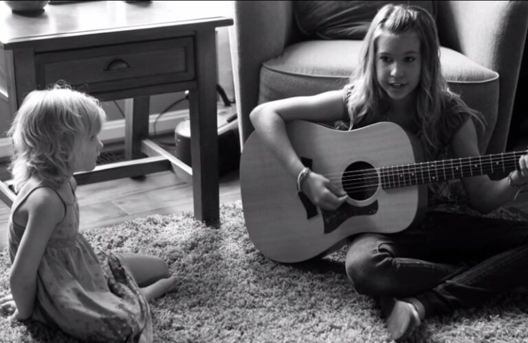 Middle schooler Abby Miller with her guitar and a friend