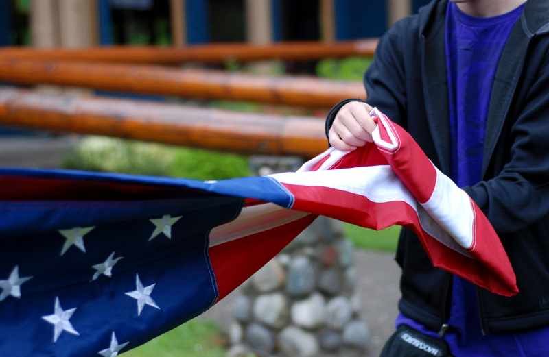 A boy folding a flag at military camp. Photo courtesy CRISTA Operation Xtreme