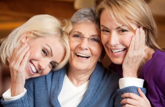 An older mother surrounded by two daughters