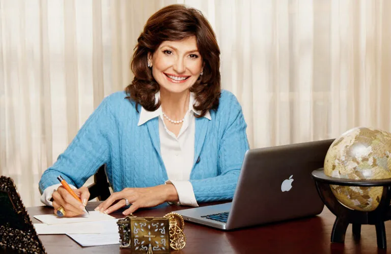 Martha Williamson sits at her desk, smiling as she writes a letter.