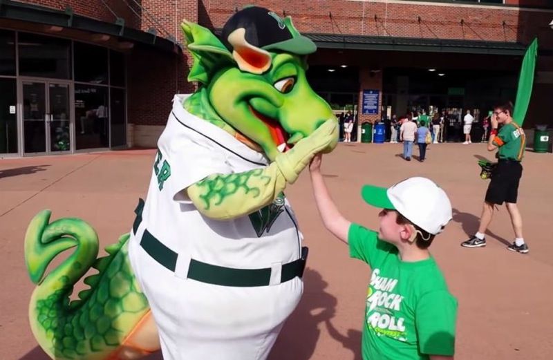 Hunter enthusiastically high fives Heater, the Dragons mascot