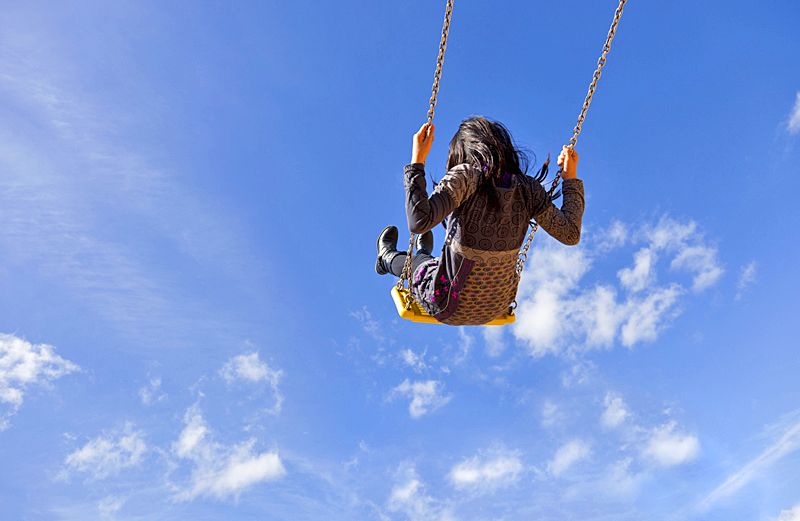 Girl swings into the sky.