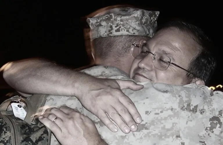 Edie's son Kirk, off for his first Iraq deployment, gets a hug from his dad.