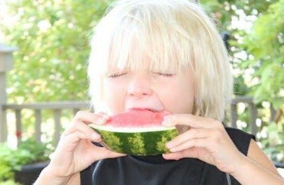 Shawnelle's young son samples sweet watermelon.