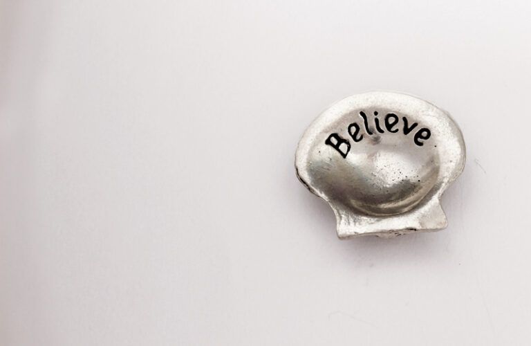 The word 'believe' inscribed on a seashell