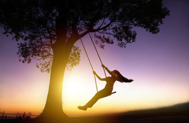 woman on a swing as the sunsets
