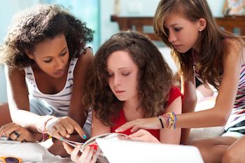 Teen girls looking at a fashion magazine. Photo from 123RF(r)