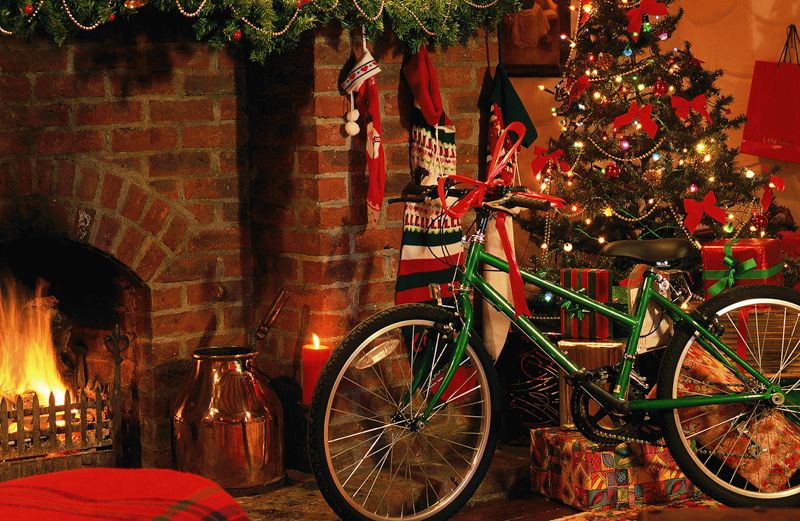 A bicycle with a ribbon under the Christmas tree