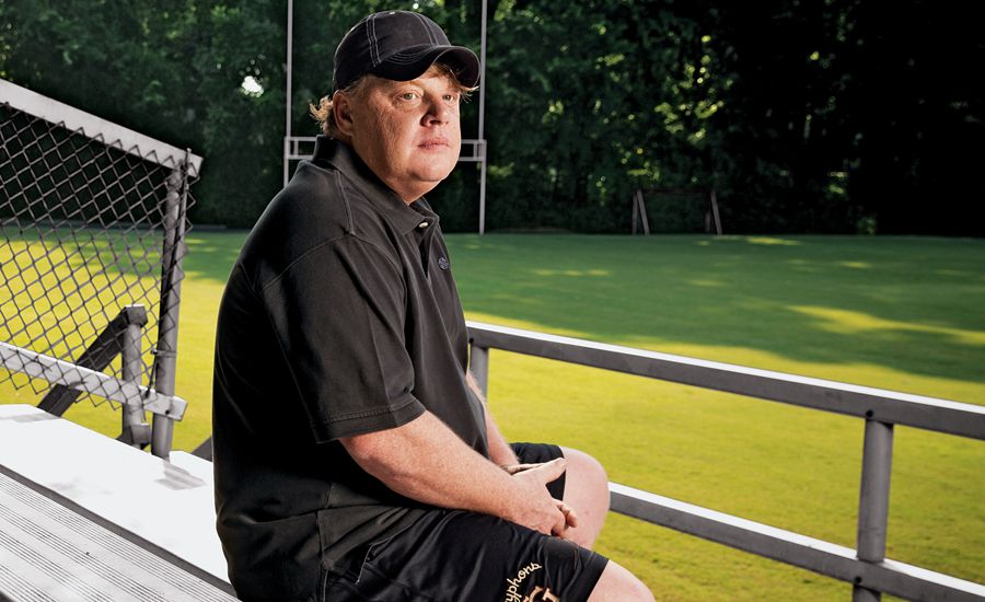 Bill Courtney sits in the empty stands at his football team's practice field.