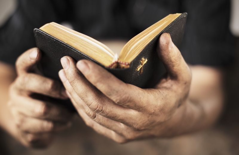 Close-up of a man holding the Bible