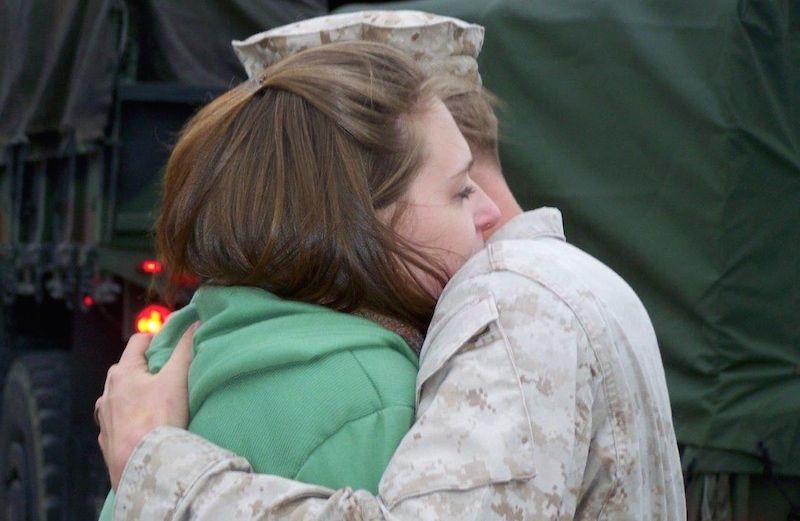 Edie's Marine Corps son hugging his wife before he's deployed