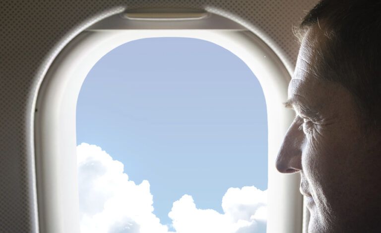 Man gazes contentedly out of plane window