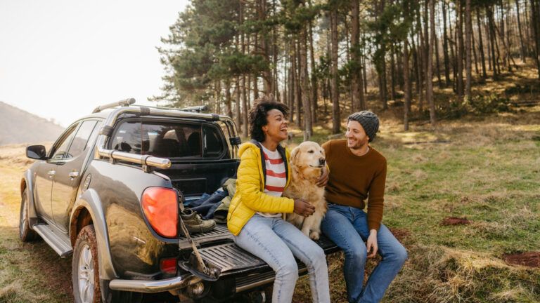 Couple sitting in their truck with their dog outside as a thing to do during lent