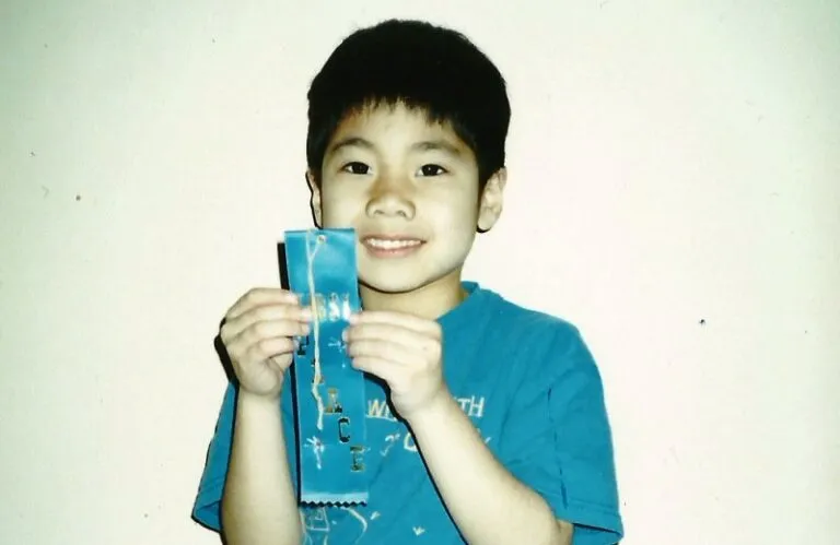 AJ holding the spelling bee first place ribbon