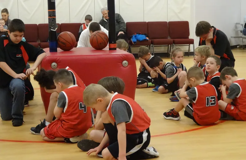 Basketball players in prayer after a game. Photo by Michelle Cox.