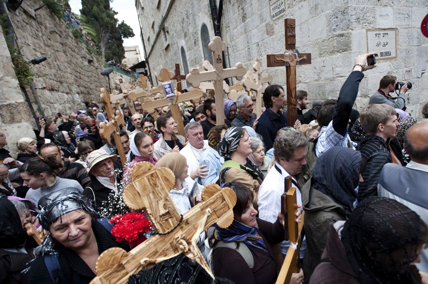 Christian pilgrims carrying crosses along the Via Dolorosa