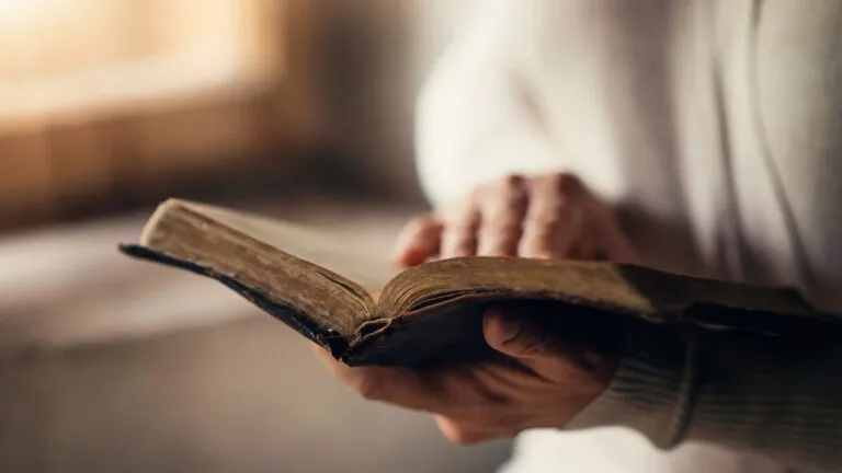 Woman reading Good Friday reflection in her old Bible