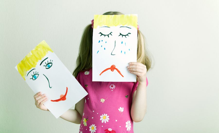 Little girl holding up a frown sign. Thinkstock.