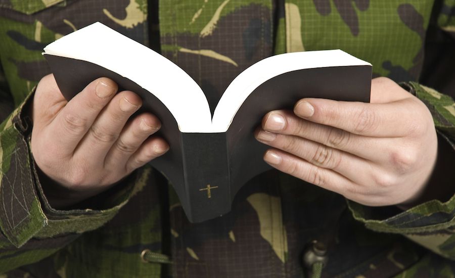 Guideposts: Soldier praying, Bible in hand.