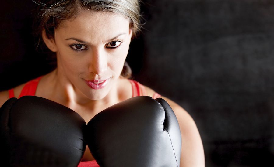 Woman wearing boxing gloves. Thinkstock.