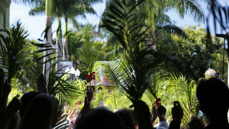 Members of a church coming out of their church for the Palm Sunday parade