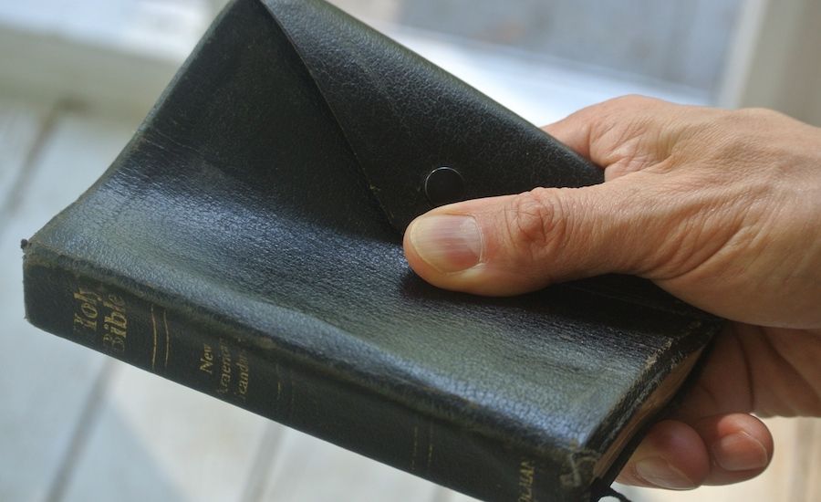 Guideposts: Hand holding a Bible.