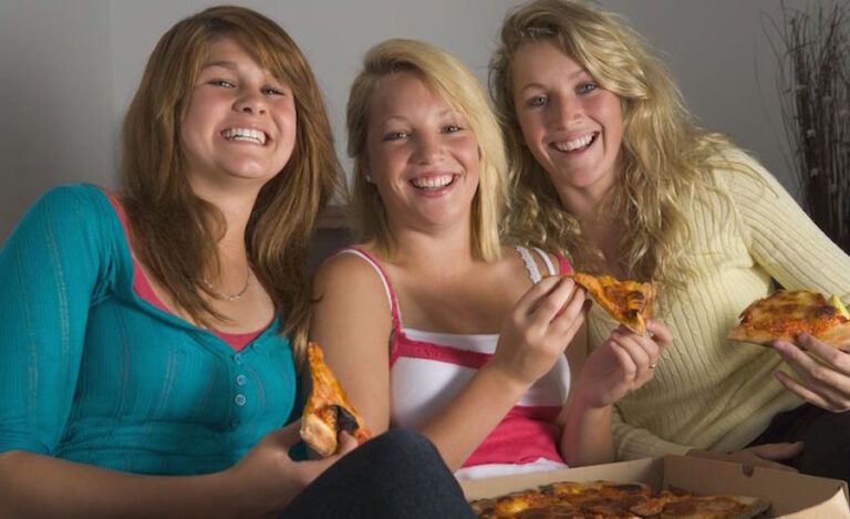 Teen girls eating pizza. Photo: 123RF(r).