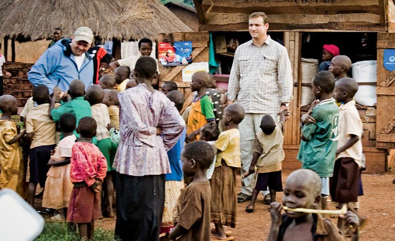 Brett (left) and his friend Jeff meet children in a village near Jinja, Uganda