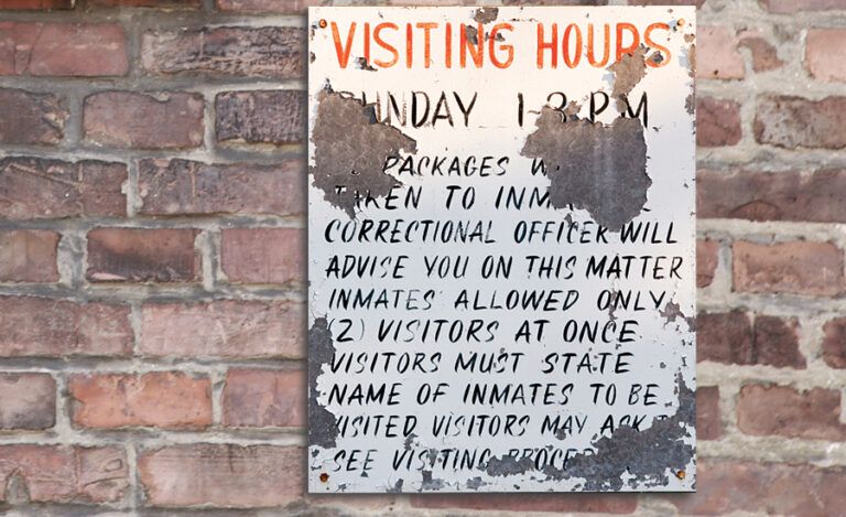 A sign listing visitor rules in a prison