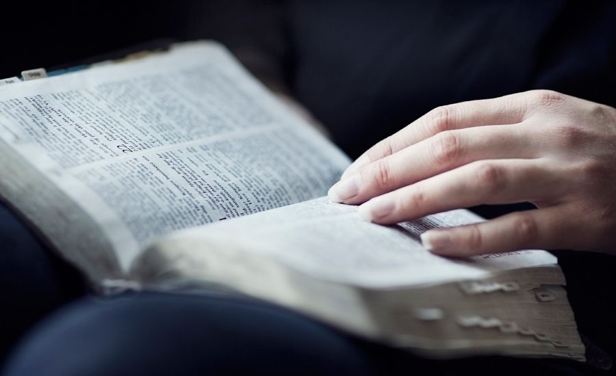A woman's hands, on an open Bible