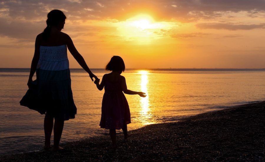 Mother and daughter walking at sunset (Thinkstock)