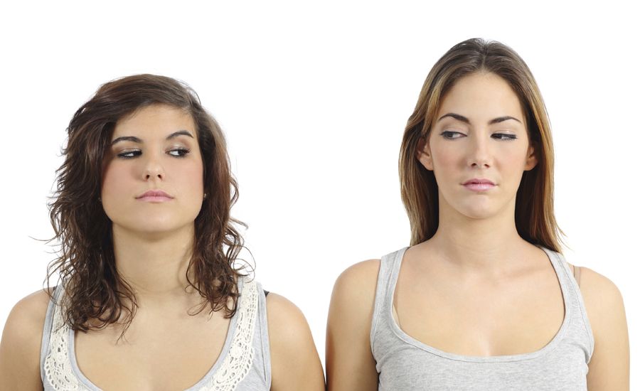 two women stare at each other as if they are suspicious of the other