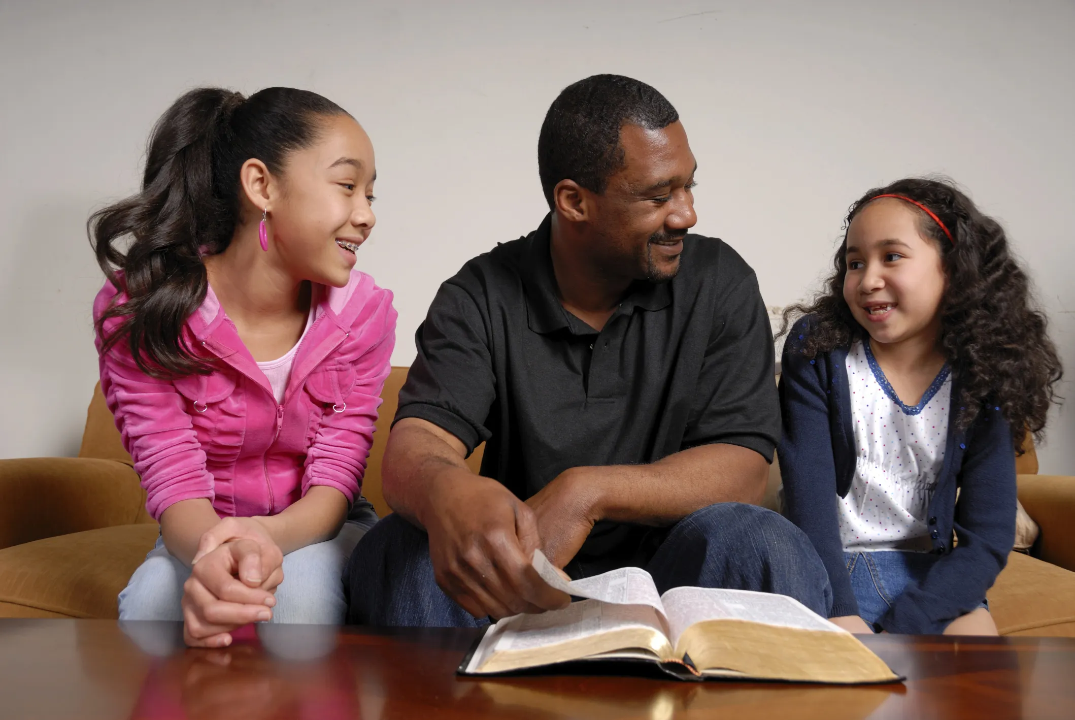 Daughters reading scripture to their dad on Father's Day