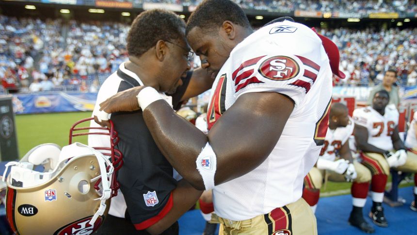 Chaplain Earl Smith prays with Moran Norris during a 2007 road game against the San Diego Chargers.