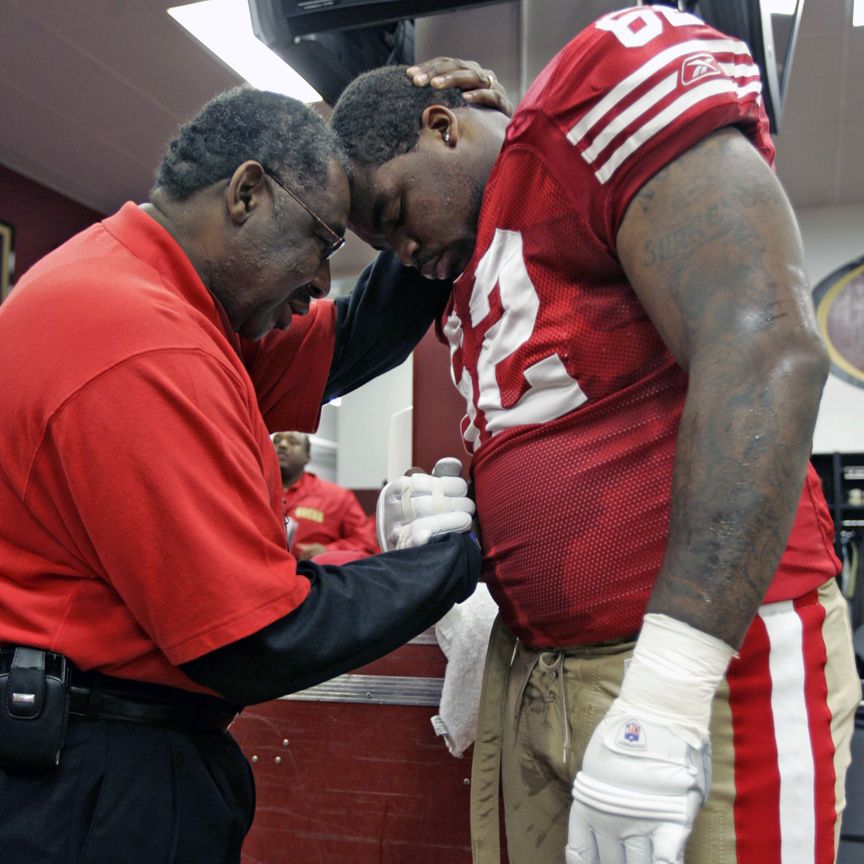 Smith ministers to Chilo Rachal in the locker room before a 2008 home game against the Washington Redskins.