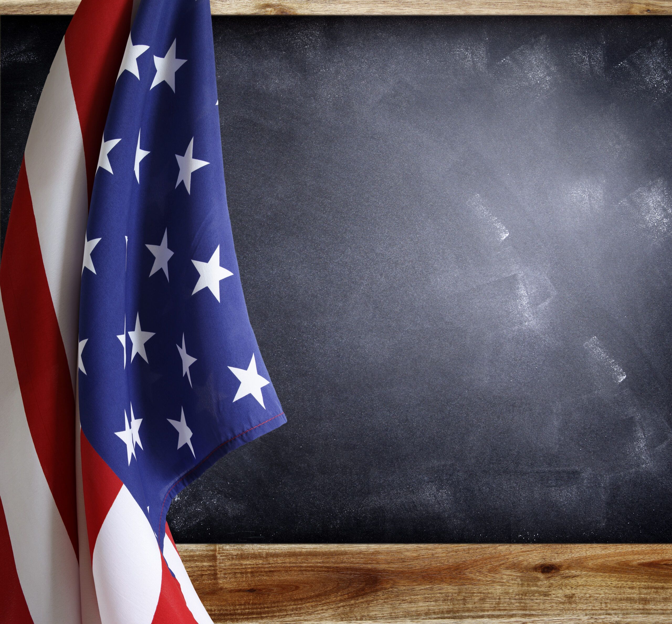 American flag hanging from a school room chalkboard