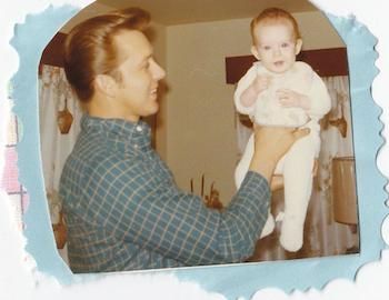 Shawnelle as a baby being held by her dad.