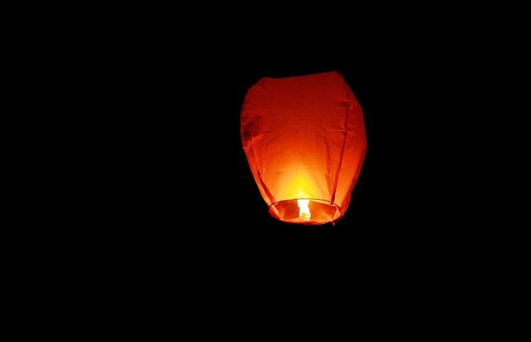 A paper lantern glowing against the night sky is a reminder of God's presence