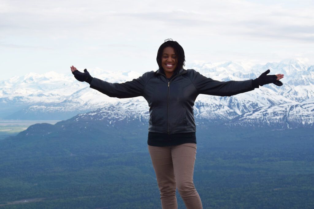 Guideposts senior digital editor Brooke Obie stands on top of an Alaskan mountain range