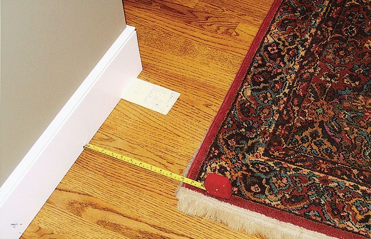 A white card marks the where the left edge of the rug was the night before this picture was taken. The rug has moved several inches.