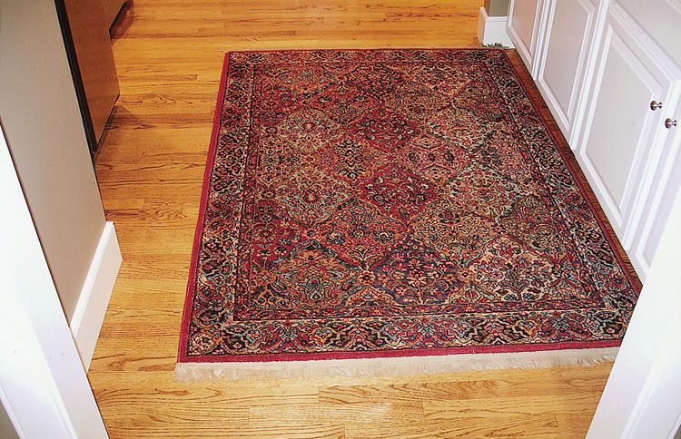 The rug has moved all the way from the hallway's left wall to the right wall, a distance of several inches.