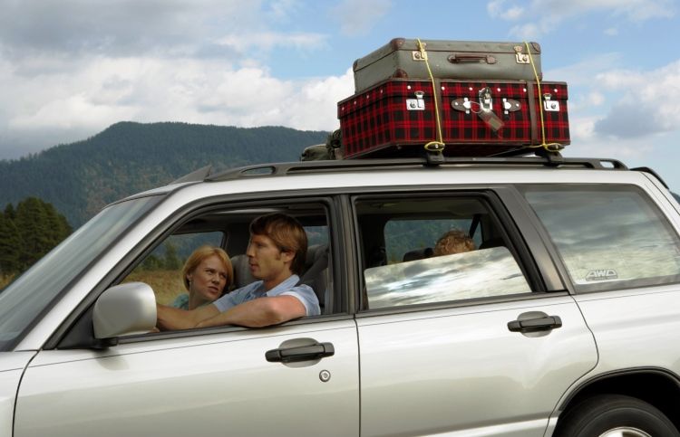 A faith-filled road trip: family in a station wagon with luggage on roof