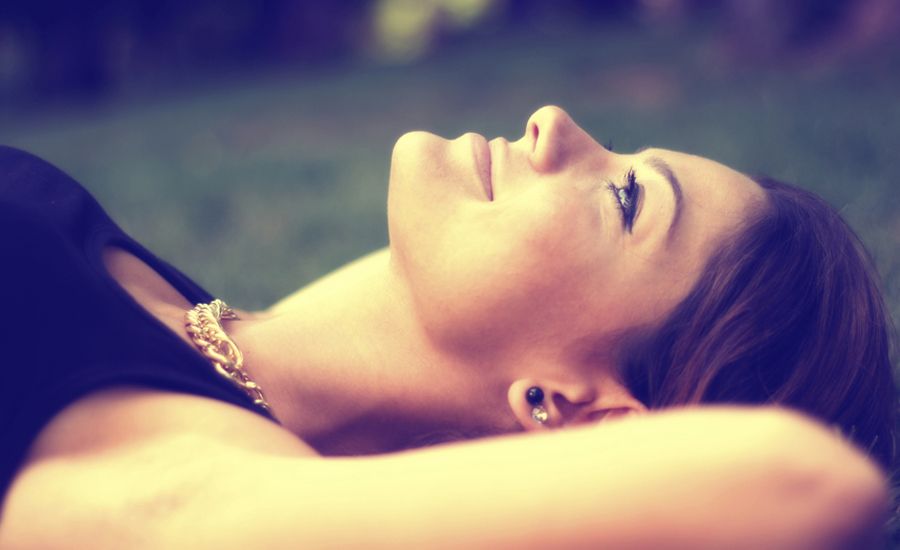 a woman lies in the grass witnessing God's glory in creation
