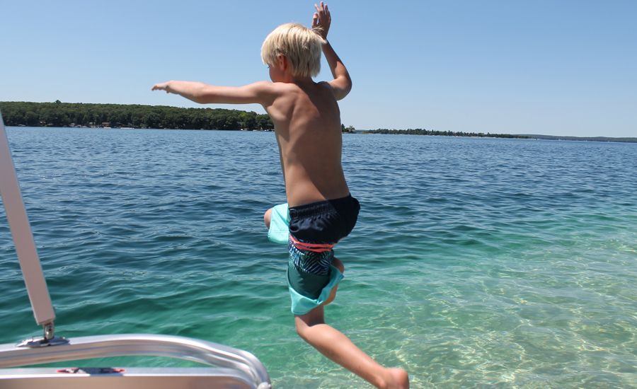 Shawnelle's son jumping off the boat into the lake in Michigan