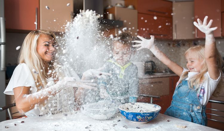 Mom and daughters playing in flour in the kitchen Author Amy Julia Becker learned 5 life lessons from her children.